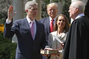 U.S. Supreme Court Associate Justice Anthony Kennedy (r) administers the judicial oath to Judge Neil Gorsuch, as his wife, Marie Louise Gorsuch, holds a Bible and President Donald Trump looks on during a ceremony in the Rose Garden at the White House April 10 in Washington. Earlier in the day, Gorsuch, 49, was sworn in as the 113th associate justice in a private ceremony at the Supreme Court.