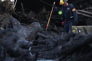 Above,  Los Angeles County urban search and rescue worker searches a pile of debris for victims of the mudslide Jan. 11, 2018 in Montecito, California. Below, Archbishop Jose Gomez of Los Angeles celebrates Mass at the Santa Barbara Mission Jan. 14.