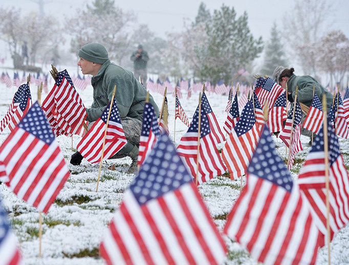 Airmen from Hill Air Force Base place flags beside gravestones at the Utah Veterans Memorial Cemetery, Bluffdale, Utah, Nov. 10, 2015. More than 5,000 flags were placed during the detail in honor of veterans and their families.