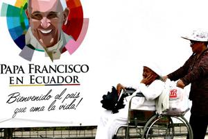  A woman is wheeled past a banner with an image of Pope Francis at Samanes Park, where Pope Francis celebrated Mass in Guayaquil, Ecuador.