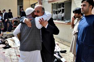 People comfort each other following a bomb blast in Quetta, Pakistan, Monday, Aug. 8. A powerful bomb went off inside a government-run hospital in the southwestern city of Quetta on Monday, killing dozens of people and wounding dozens of others, police said.