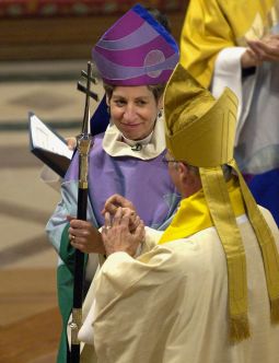 Bishop Katharine Jefferts Schori takes the primatial staff from outgoing Bishop Frank Griswold at her investiture as the presiding bishop of the Episcopal Church at the National Cathedral in Washington Nov. 4. The ordination of women as priests and bishops is one reason some Anglicans are leaving the church — and seeking membership in the Catholic Church.
