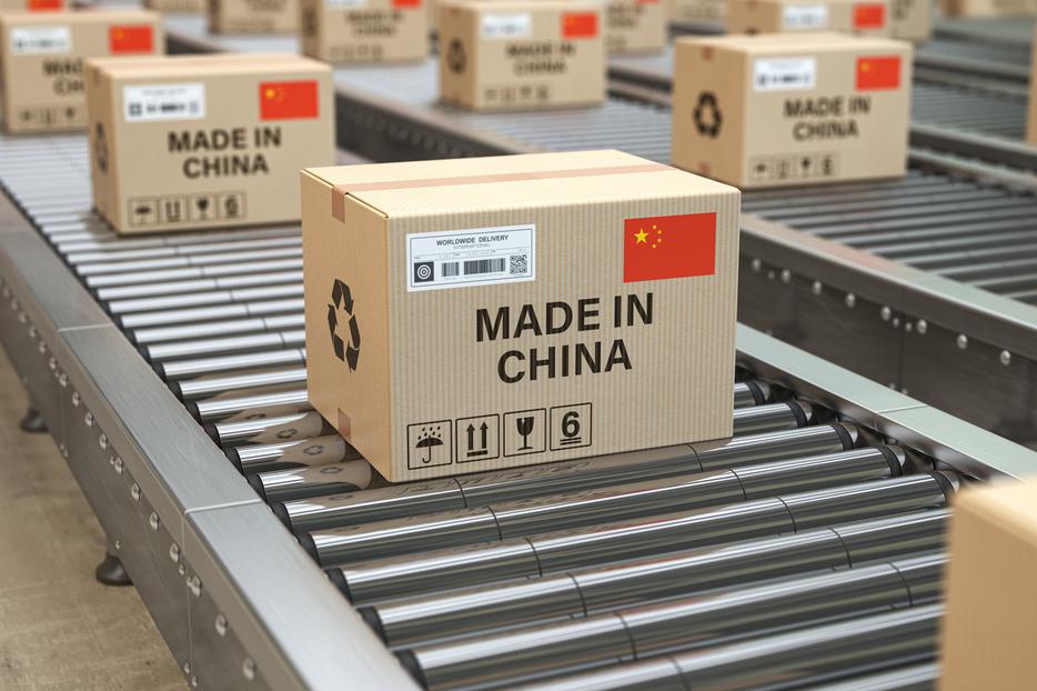 Cardboard boxes with text made in China and Chinese flag on the roller conveyor. U.S. government acted on Sept. 14, 2020 to withhold release of 5 categories of items from the Chinese province of Xinjiang and Anhui