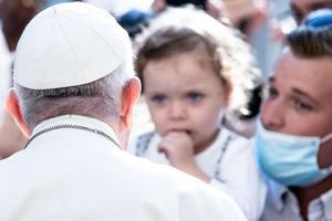 Pope Francis greets pilgrims including a father holding his small child on September 16, 2020.