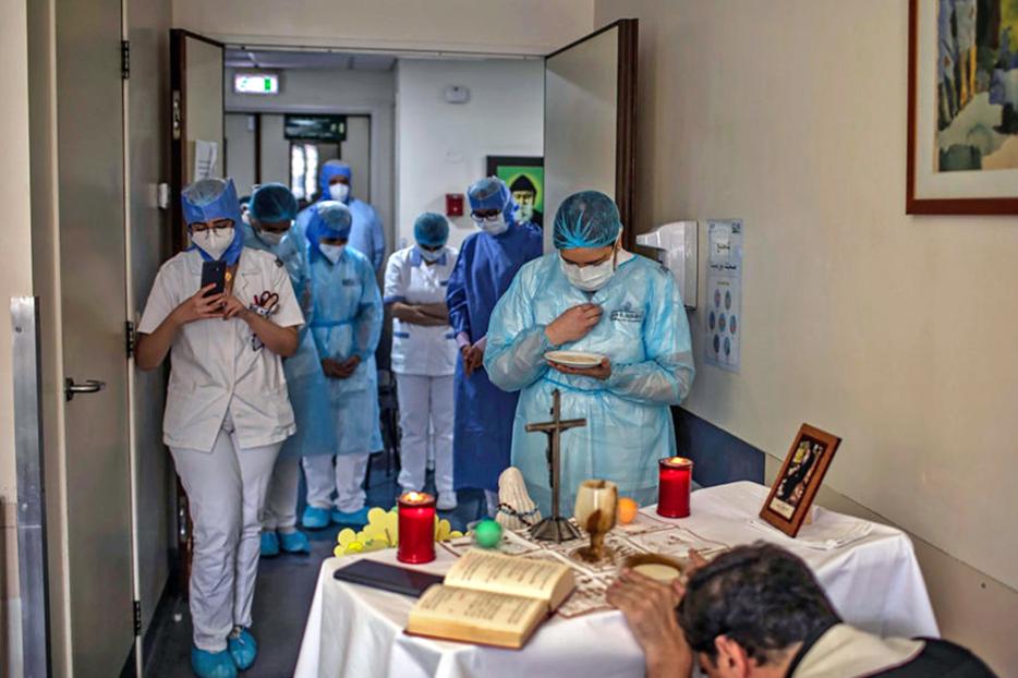 A picture taken by a nurse on May 8 at the Hôtel Dieu de France Hospital in Beirut, Lebanon, shows health workers gathered to attend a Mass offered by a priest in the COVID-19 section of the hospital.