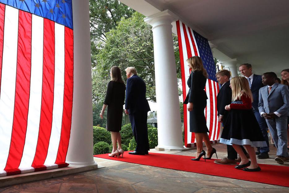 President Donald Trump Judge Amy Coney Barrett walk into the White House Rose Garden on Saturday with first lady Melania Trump and Barrett's family to present Barrett as his nominee to the Supreme Court.
