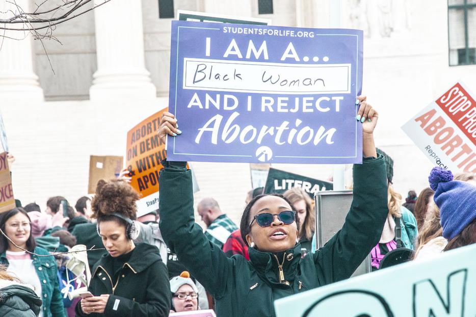 ‘I Am a Black Woman and I Reject Abortion,’ proclaims a sign held aloft by a participant at the annual March for Life.