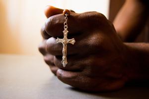 A Nigerian man holds a crucifix.