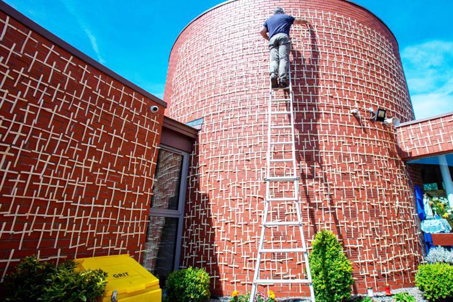 Patrick Hand adds more white palm crosses to the 2,000 that have been placed on the walls of the Church of the Ascension of the Lord in Balally, south Dublin, Ireland, on May 20, 2020. Each cross represents a victim of the COVID-19 pandemic. More than 2,000 crosses have been placed on the red brick walls in memory of those who have died in Ireland and Northern Ireland, which is equal to the approximate number of abortions in the U.S. each day.