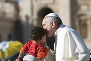 Pope Francis on the popemobile kiss child in St. Peter's Square on november 6 2013.