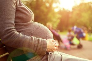 Pregnant woman sitting on a park bench