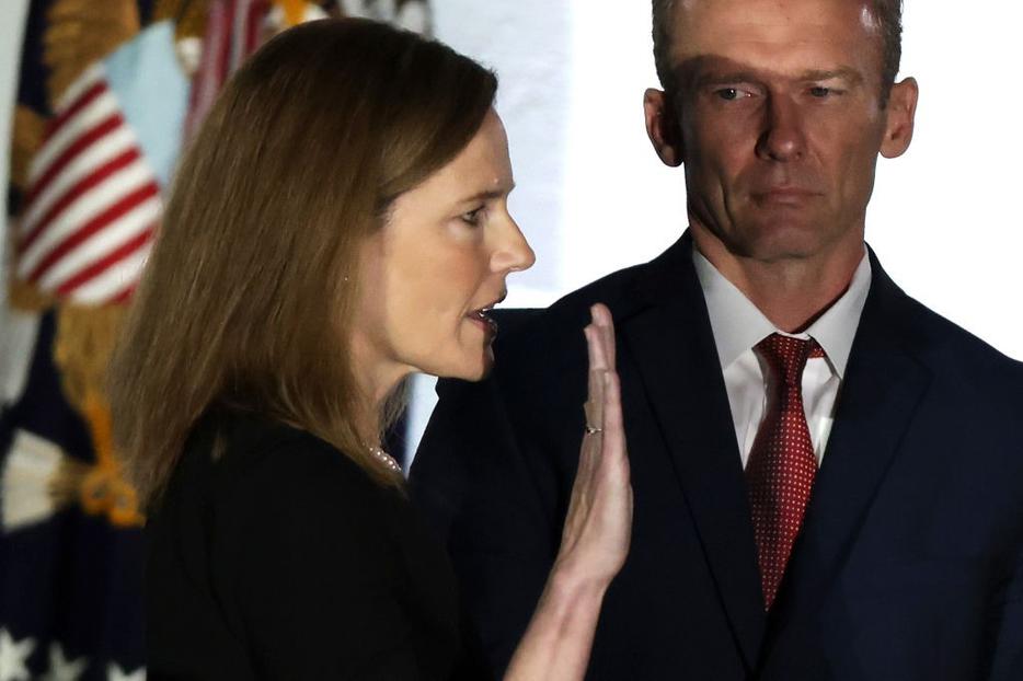 Judge Amy Coney Barrett is sworn in as a U.S. Supreme Court associate justice during a ceremony on the South Lawn of the White House Oct. 26. Her husband, Jesse, looks on.