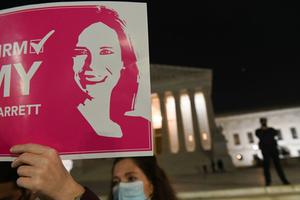 A pro-life activist and a supporter of naming Judge Amy Coney Barrett as a Supreme Court Justice, holds a sign in front of the Supreme Court building in Washington, DC on October 26, 2020.