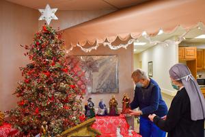 Resident Betsy Balmes of the Mullen Home in Denver and Sister Carolyn Martin, of the Little Sisters of the Poor, who is a nurse, administrator and vocations outreach manager at the Mullen Home, work together on the Christmas display in the first floor coffee shop.