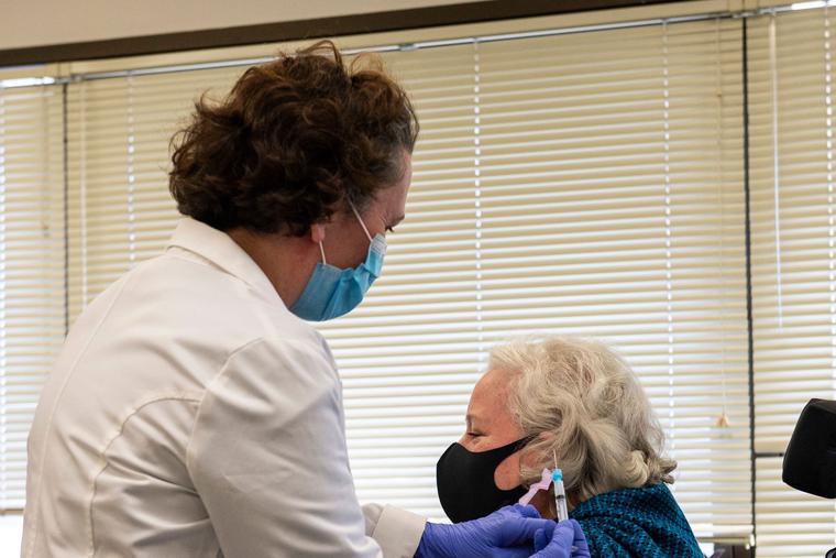 Pharmacist Serena Burgdorf administers a Covid-19 Moderna vaccine shot to Christine Griffin, Army Veteran, who has a spinal injury and is inpatient at the West Roxbury VA Medical Center in Boston, MA on December 23, 2020. The VA is vaccinating front line workers and at risk patients during phase one.