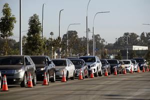 Vehicles wait in line to receive groceries during a holiday mobile food distribution from the Los Angeles Regional Food Bank on Dec. 22, 2020, in Inglewood, California. The food bank has distributed 145 million pounds of food since the COVID-19 pandemic started.