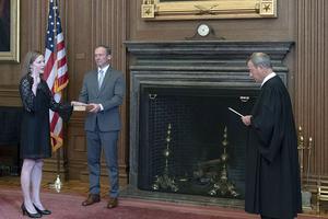 Chief Justice John G. Roberts, Jr., administers the judicial oath to Judge Amy Coney Barrett in the East Conference Room of the Supreme Court Building. Judge Barrett's husband, Jesse M. Barrett, holds the Bible.