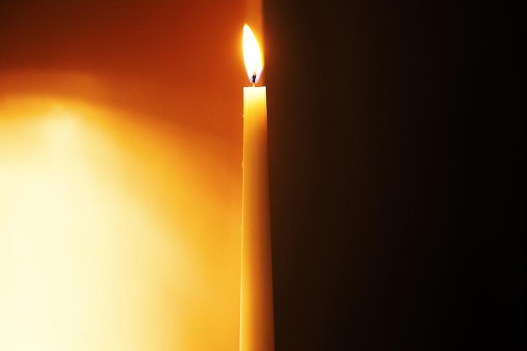 A candle separates dark from light.