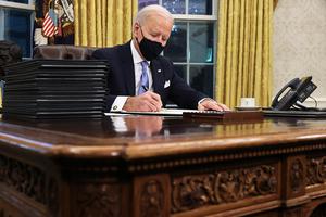 U.S. President Joe Biden prepares to sign a series of executive orders at the Resolute Desk in the Oval Office just hours after his inauguration today in Washington, D.C.