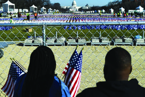 People collect flags that decorated the National Mall in Washington on Jan. 21, one day after the inauguration of U.S. President Joe Biden. The Presidential Inaugural Committee encouraged supporters to sponsor the flags through donations to 95 groups, including the Planned Parenthood Federation of America.