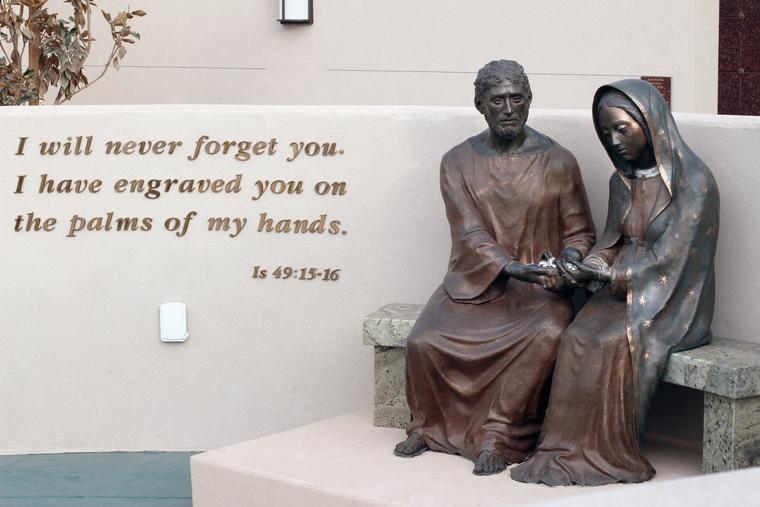 The memorial walls are centered around a life-size bronze statue of St. Joseph and Our Lady of Guadalupe, co-patrons of the unborn. Together they hold an unborn baby in their hands.