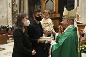 A Roma soccer player Lorenzo Pellegrini and his family receive a Bible from Archbishop Rino Fisichella, in St. Peter's Basilica Jan. 24, 2021.