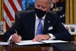 US President Joe Biden signs a series of orders in the Oval Office of the White House in Washington, DC, after being sworn in at the US Capitol on January 20, 2021.