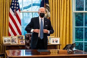President Joe Biden stands after signing an executive order in the Oval Office of the White House on January 25, 2021 in Washington, DC. President Biden signed an executive order repealing the ban on transgender people serving openly in the military.
