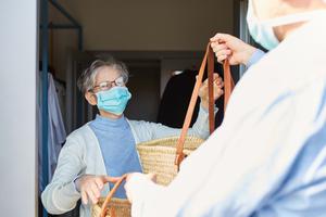 An elderly woman receives groceries amid the coronavirus pandemic.