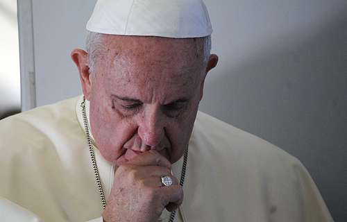 Pope Francis prays with journalists on the papal flight to South Korea, Aug. 14, 2014.
