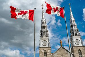 Canadian flags in the forefront of the Notre-Dame Cathedral Basilica in Ottawa. Canada