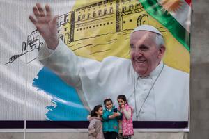 Young girls take a selfie in front of a poster promoting the upcoming trip of Pope Francis on March 4, 2021 in Erbil, Iraq. On March 5, Pope Francis will start the historic first ever papal visit to Iraq. In his first foreign trip since the start of the pandemic Pope Francis will visit Baghdad, Najaf, Erbil and the cities of Qaraqosh and Mosul, which were heavily destroyed by ISIS.