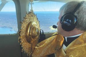 Father Brian Gannon, pastor of St. Theresa Church, flies across the Diocese of Bridgeport, Connecticut, holding a monstrance as he offers a Eucharistic blessing to local Catholics.