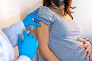 A pregnant mother receives the COVID-19 vaccine shot.