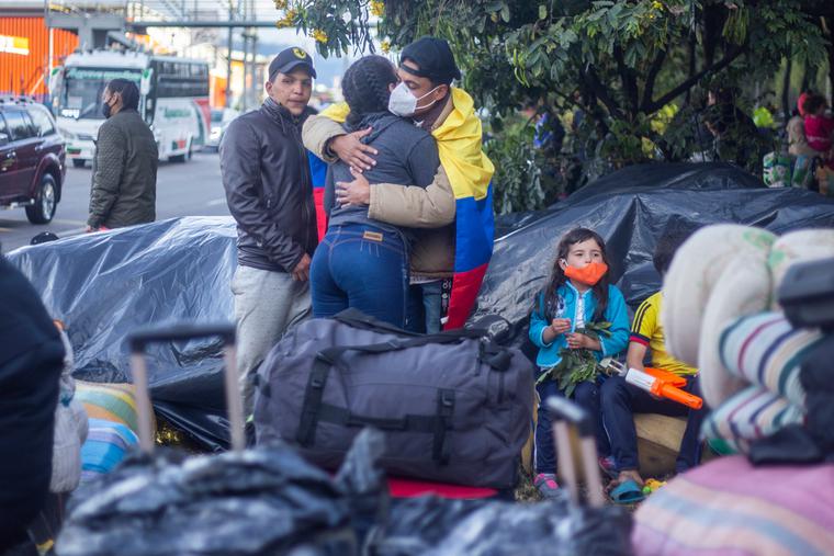 Several immigrants from Venezuela with suitcases on the street waiting to return to their country.