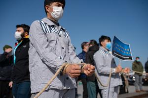 Members of the Muslim Uyghur minority keep symbolically their hands tied with a rope as they demonstrate to ask for news of their relatives at Uskudar square in Istanbul on February 26, 2021.