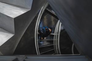 A student walks down a spiral staircase on way to class.
