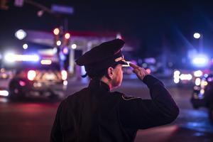 A police officer salutes as a procession carrying the body of Officer Eric Talley, a Catholic father of seven, leaves the King Soopers grocery store where a gunman opened fire Tuesday in Boulder, Colorado. Ten people, including Officer Talley, were killed in the attack.