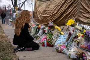 A mourner visits the location where a gunman opened fire at a King Sooper's grocery store on Monday on March 23, 2021 in Boulder, Colorado. Ten people were killed in the attack.