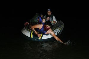 A smuggler paddles ashore a group of migrants entering the U.S. on the Rio Grande on March 30, 2021 in Roma, Texas. The group made up of individuals from Central America turned themselves into the U.S. Border Patrol after crossing as they seek asylum in the United States.