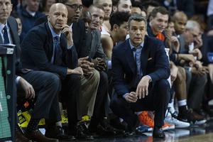 Virginia Cavaliers Assistant Coach Brad Soderberg (l) and Head Coach Tony Bennett (c) look on from the bench during the first half of the game between the Pittsburgh Panthers and the Virginia Cavaliers on March 2, 2019, at John Paul Jones Arena in Charlottesville, Virginia. The Cavs went on to win the 2019 NCAA National Championship.
