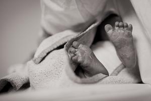 A premature newborn swaddled in a blanket.