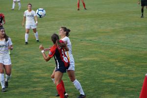 High school girls play a soccer game.