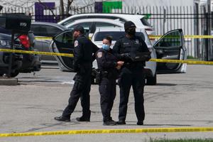 Police officers stand guard outside the site of a mass shooting at a FedEx facility in Indianapolis, Indiana on April 16, 2021.