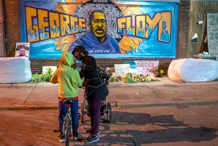 Shannon Haynes talks to her son Ronald Haynes, 9, about George Floyd in front of a memorial following the verdict in the Derek Chauvin trial on April 20 in Minneapolis. The former Minneapolis police officer was found guilty today on all three charges he faced in the death of Floyd last May.