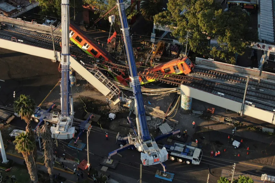 Construction crews attend to the collapsed cars of the elevated metro line in Mexico City, May 4, 2021.