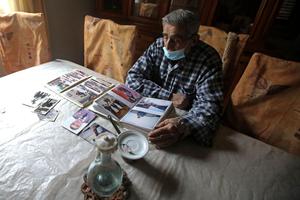 Jean Assaf, an 80-year-old retired police officer who earns a monthly pension worth around $180, down from $1,400 before the crisis, looks at an old photo album at his home in Beirut’s Mar Mikhael district on March 24. Lebanon is in the grips of its worst economic crisis since the 1975-1990 civil war, with more than half of its population living in poverty.