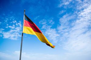 Flag of Germany waves in the breeze on a clear day in Berlin.