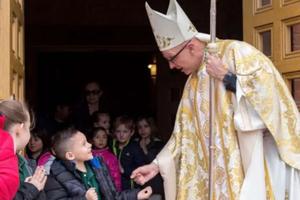 Bishop James Wall of Gallup, New Mexico, greets young parishioners following Mass at Sacred Heart Cathedral.