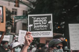 A participant holds up a sign with a quote from Pope St. Paul VI at a June 2020 rally in Atlanta.